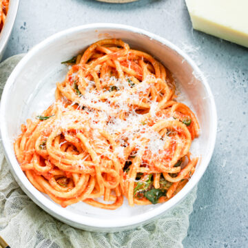 plated bowl of spaghetti with grated cheese on it