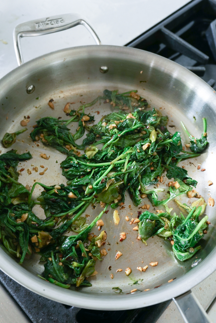 wilted baby spinach in a pan