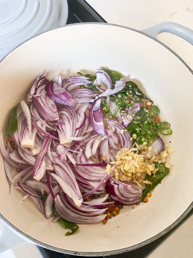 onions, ginger and green chillies in an enameled cast iron pot