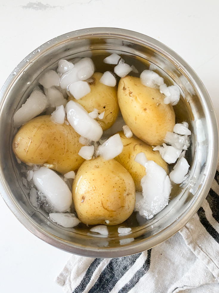 cooked potatoes in a bowl with water and ice