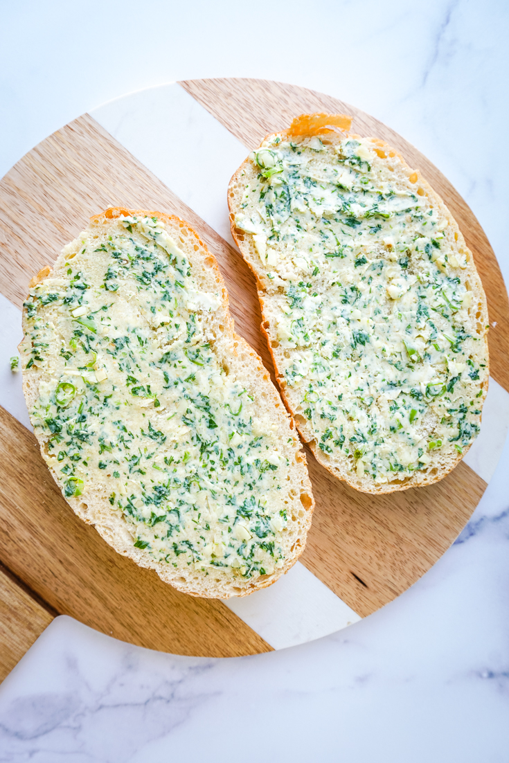 garlic herb butter spread on two halves of the bread