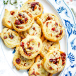 a blue and white platter full of cranberry brie pinwheels