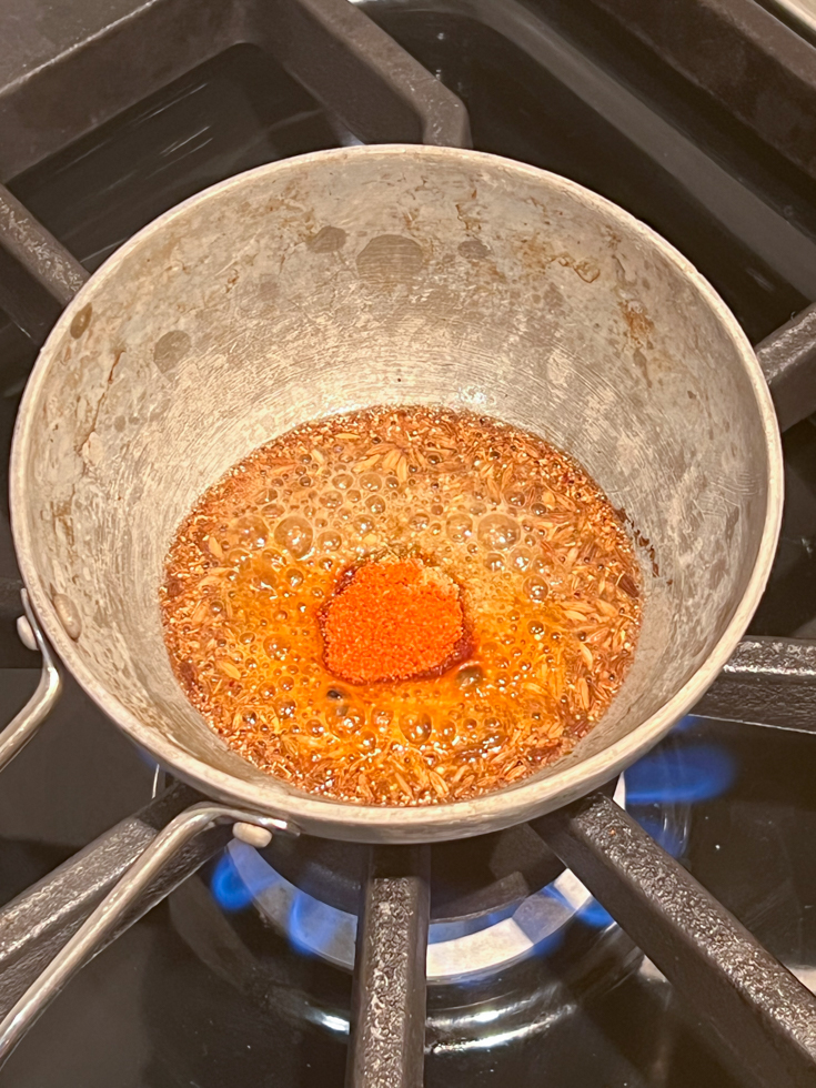 tadka of cumin and cayenne in hot oil in a small pan