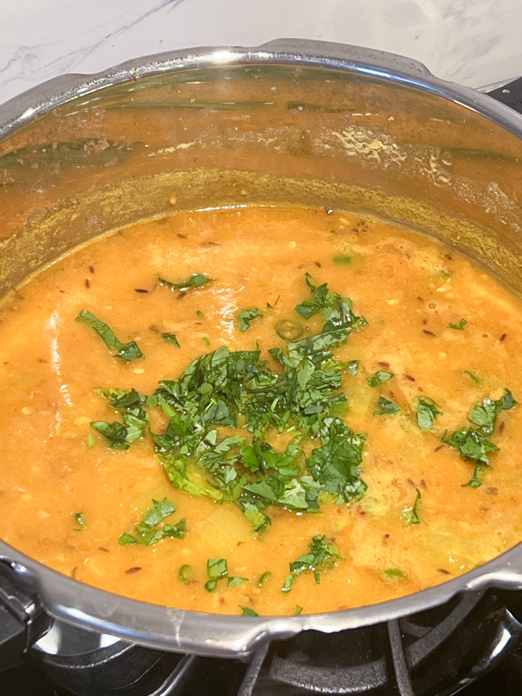 lauki chana dal topped with cilantro in a pressure cooker