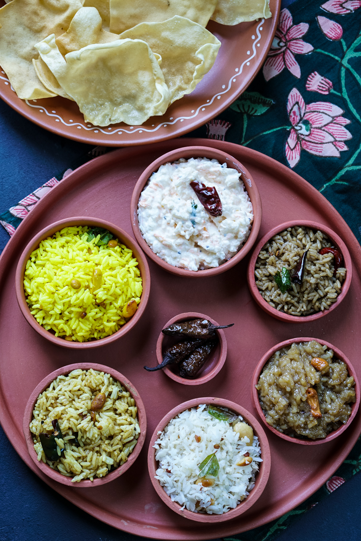 A clay platter with clay bowls of different kinds of rice