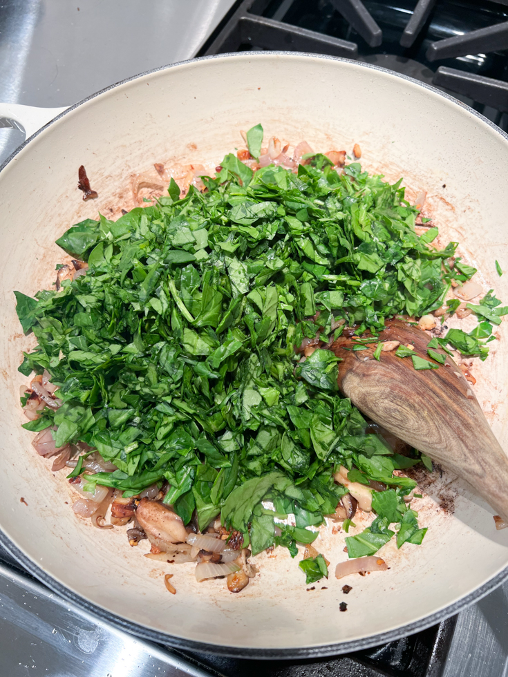 chopped spinach added to a pan