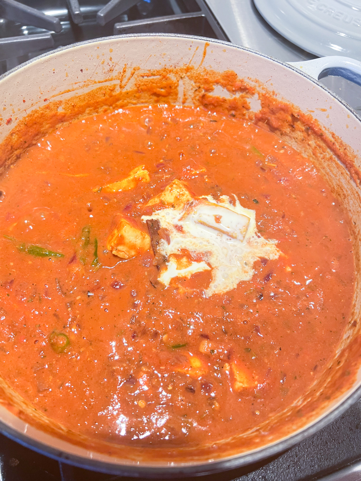 cream added to paneer masala in a dutch oven