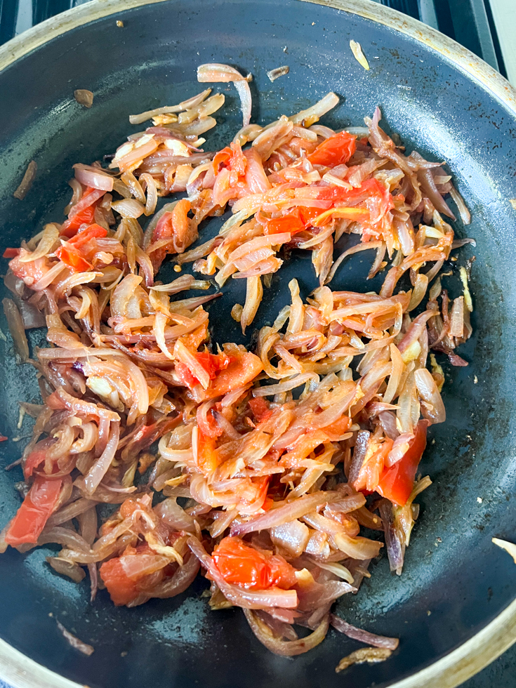 sauteed onions and tomatoes in a pan