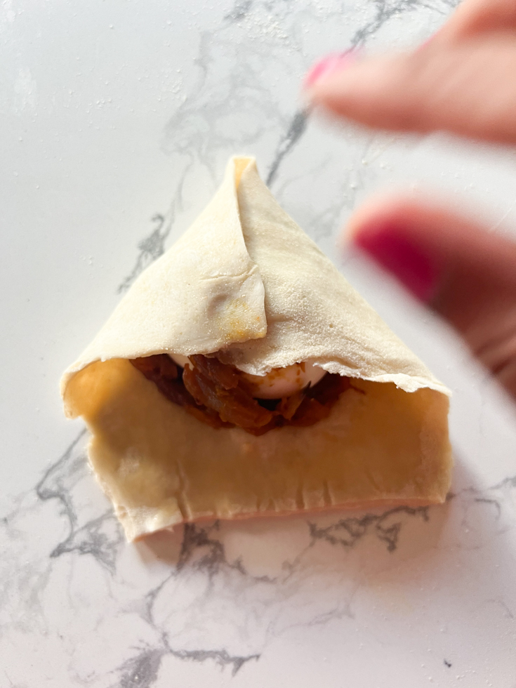 hand folding puff pastry to make egg puffs