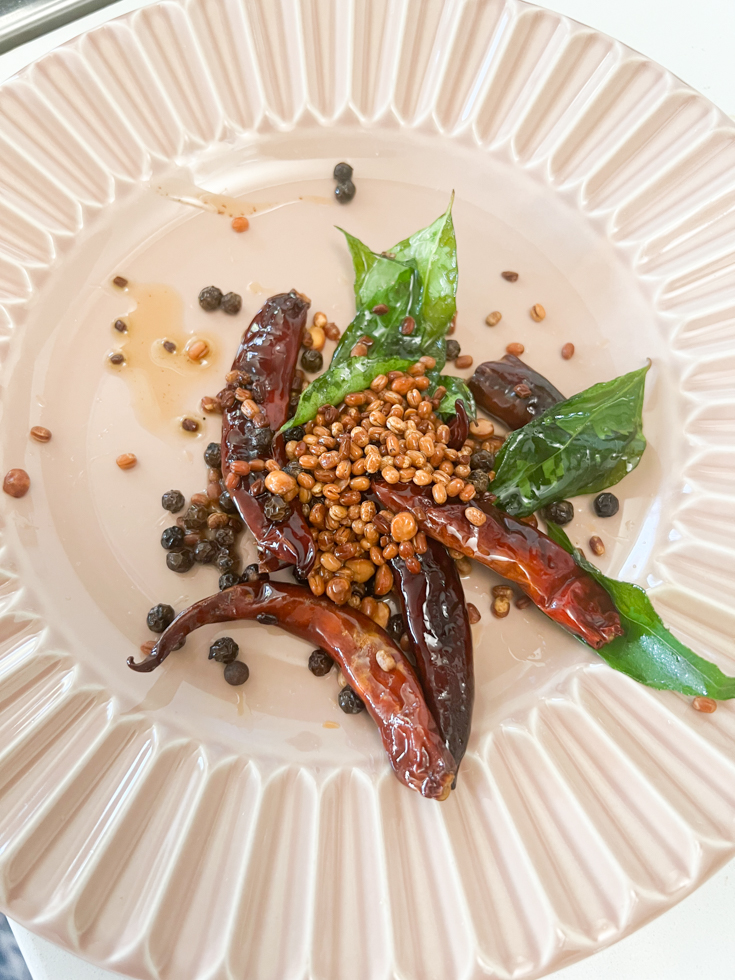roasted lentils, chillies and curry leaves in a pink plate