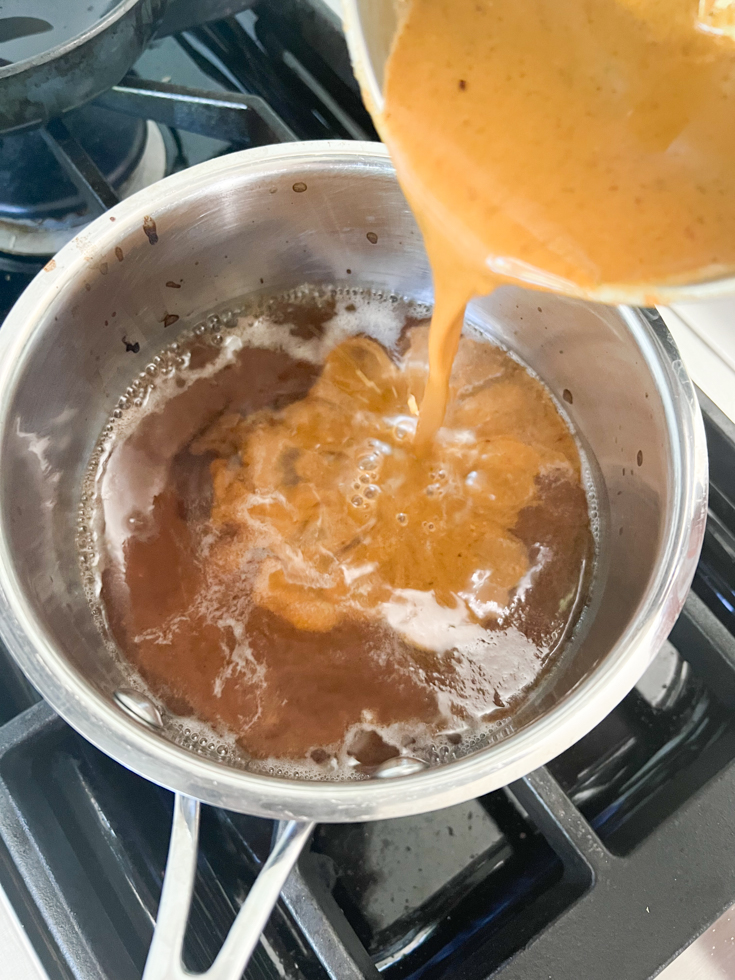 lentil puree being added to the tamarind water in the saucepan