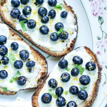 Greek Yogurt and Blueberry topped toasts on a white platter