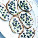 Greek Yogurt and Blueberry topped toasts on a white platter