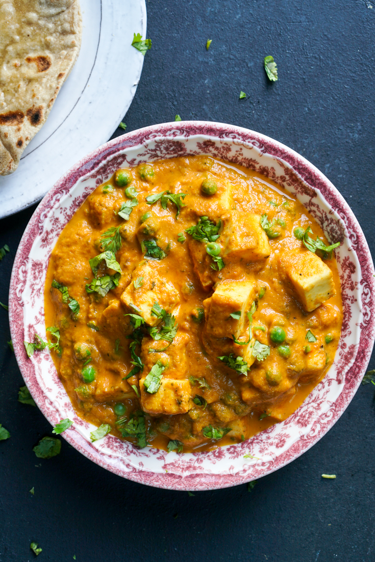 matar paneer in a red and white bowl
