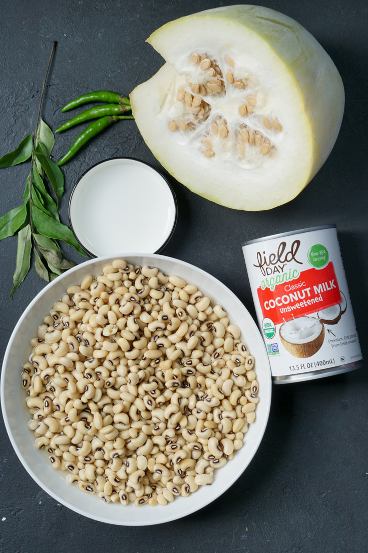 ingredients laid out - a bowl of black eyed peas, can of coconut milk, melon, curry leaves and three green chillies