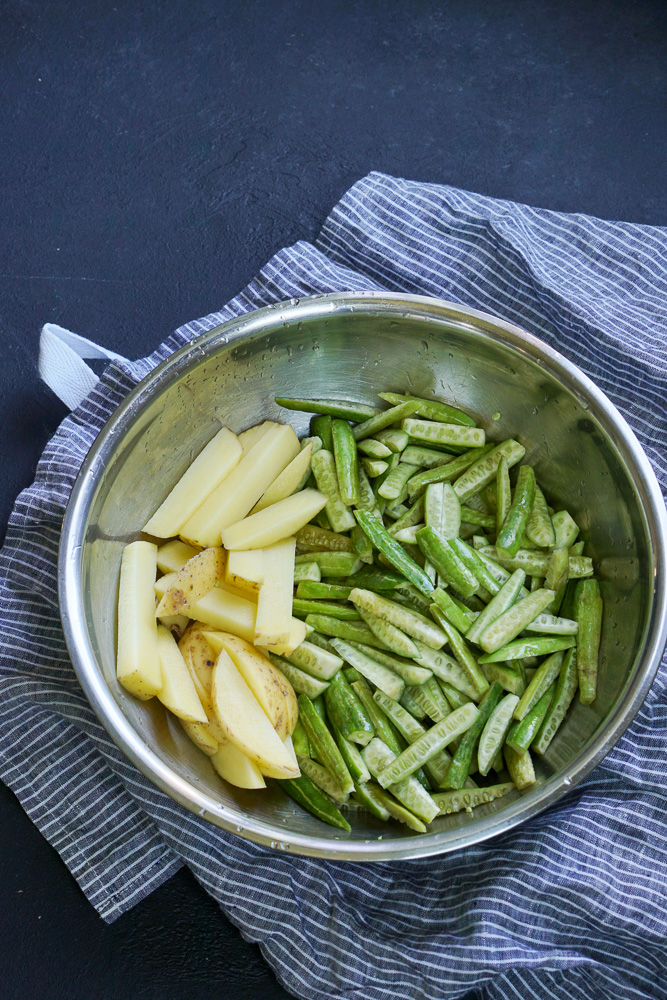 long thin slices of potato and ivy gourd in a steel bowl placed on a kitchen towel