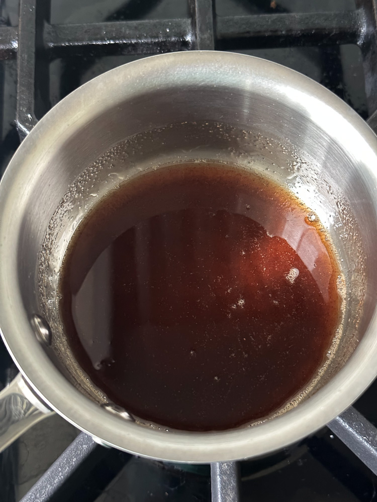 a sauce pan with syrup in it on the stove top